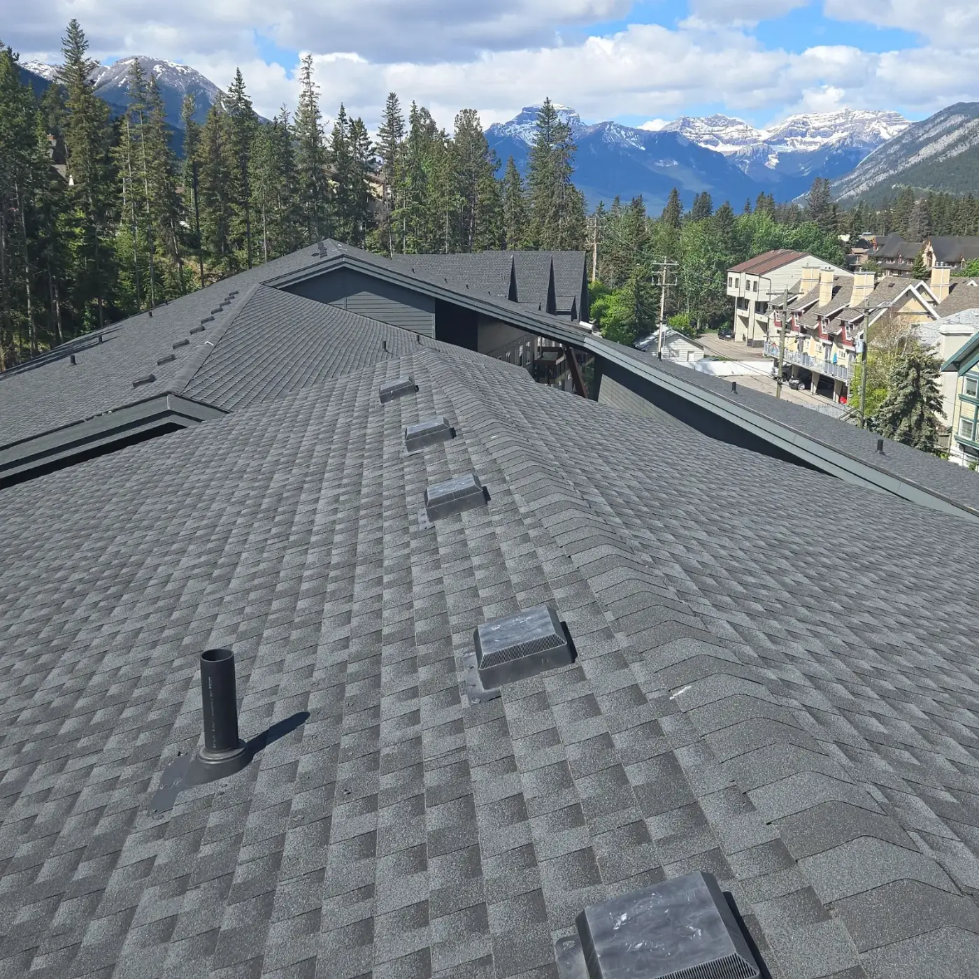 Roof inspection on a 131-unit condo building in Banff, with the mountains behind