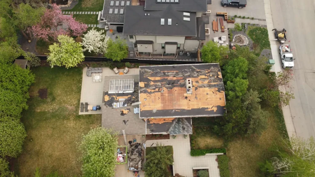 Drone view of an inner southwest Calgary home stripped to the roof deck during a Bears Valley roof replacement