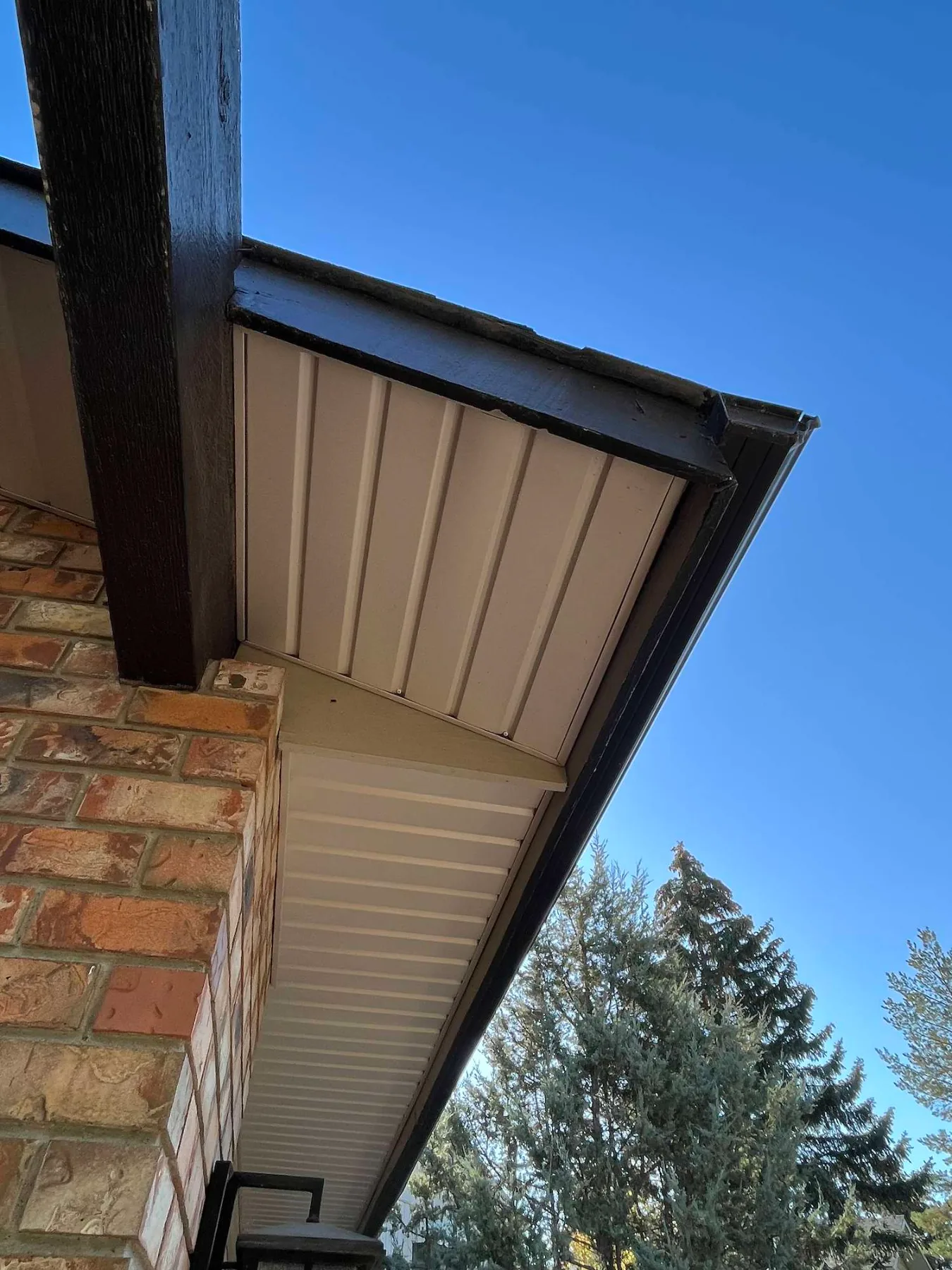 New white soffit, dark fascia and eavestrough on a brick home in Calgary