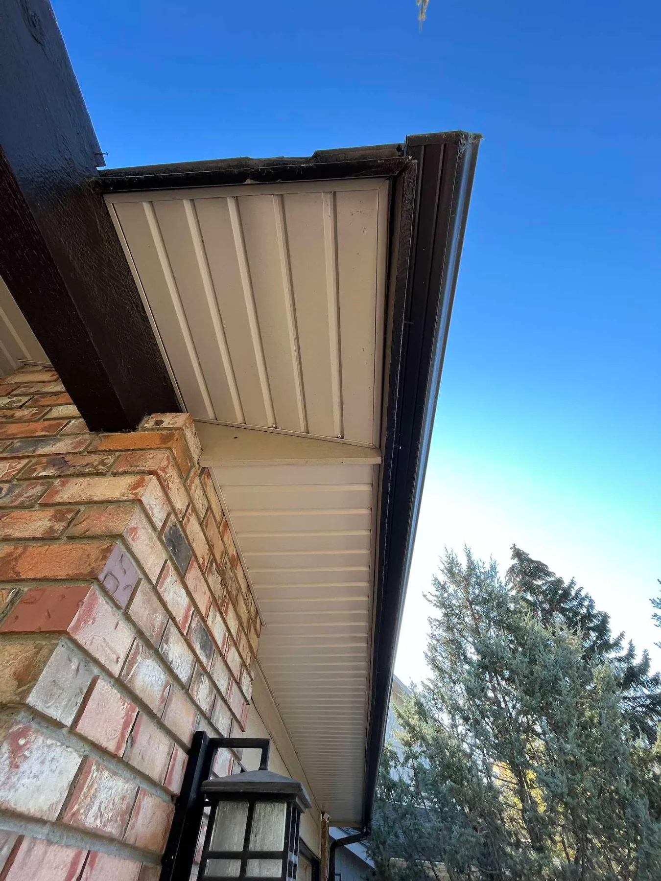 New soffit, fascia and eavestrough at a roof corner on a brick home in Calgary