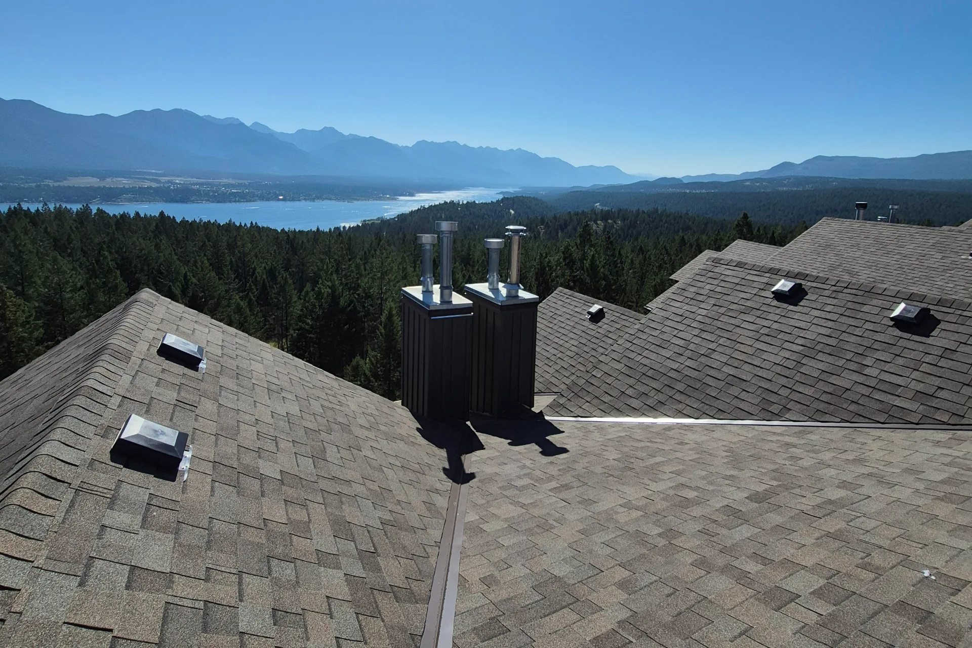 New shingle roof on a strata building with a lake and mountain view
