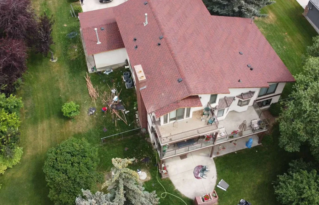 New red architectural shingle roof on a two-storey home in Dalhousie, Calgary, drone view