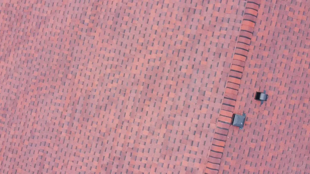 Close-up of new red architectural shingles and hip ridge cap on a Dalhousie, Calgary roof