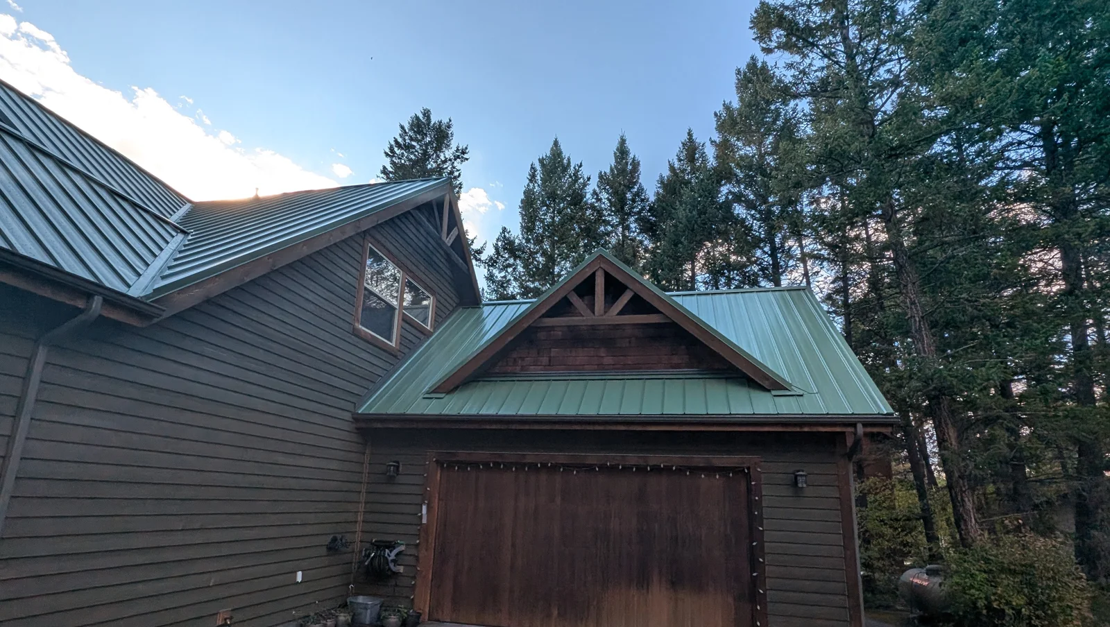 Green standing-seam metal roof on a garage