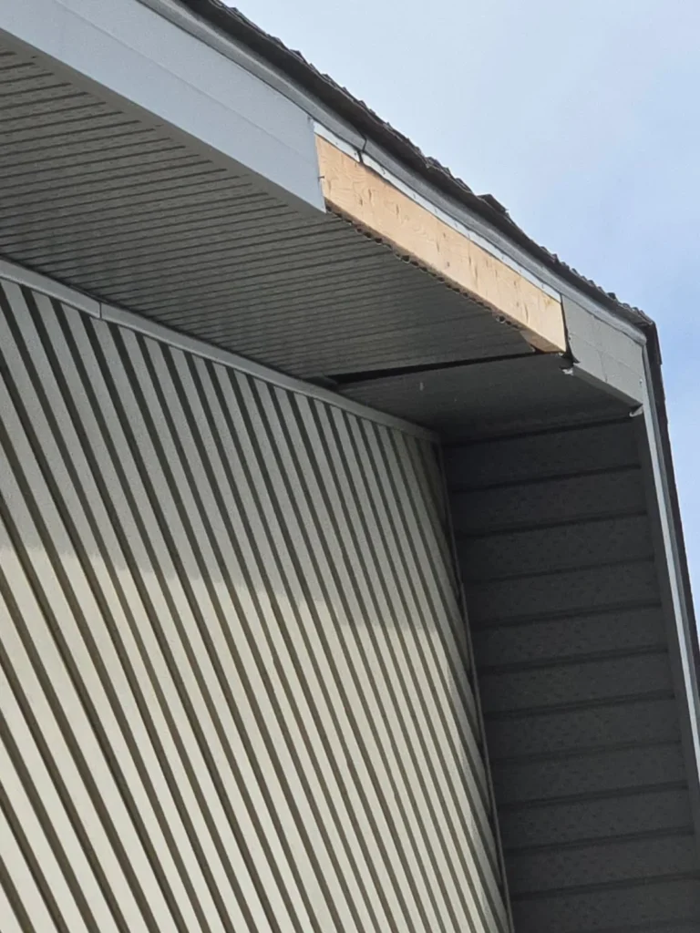 Damaged fascia and soffit at an eave corner on an Okotoks home