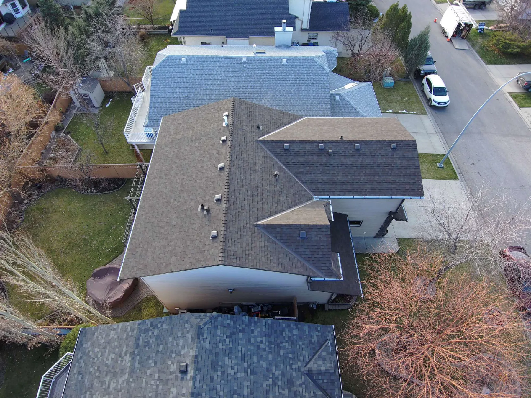 Overhead view of new shingle roofs on neighbouring homes on a Riverbend, Calgary cul-de-sac