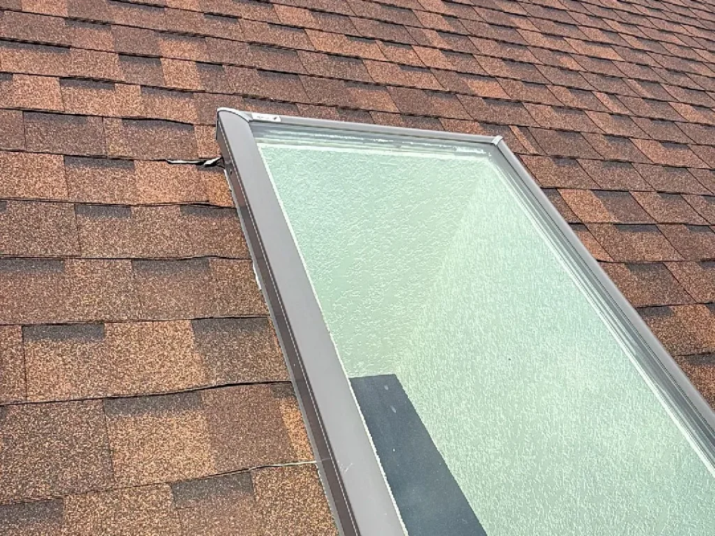 Skylight and flashing checked during a roof inspection