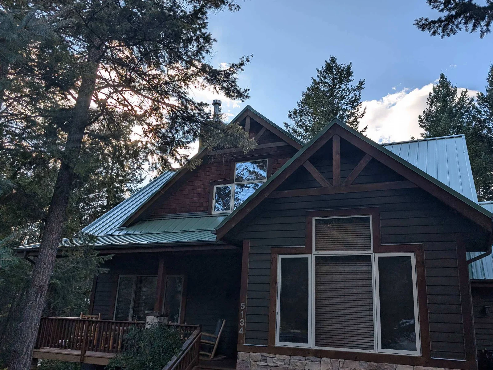 A timber-accented home with its new green metal roof, BC