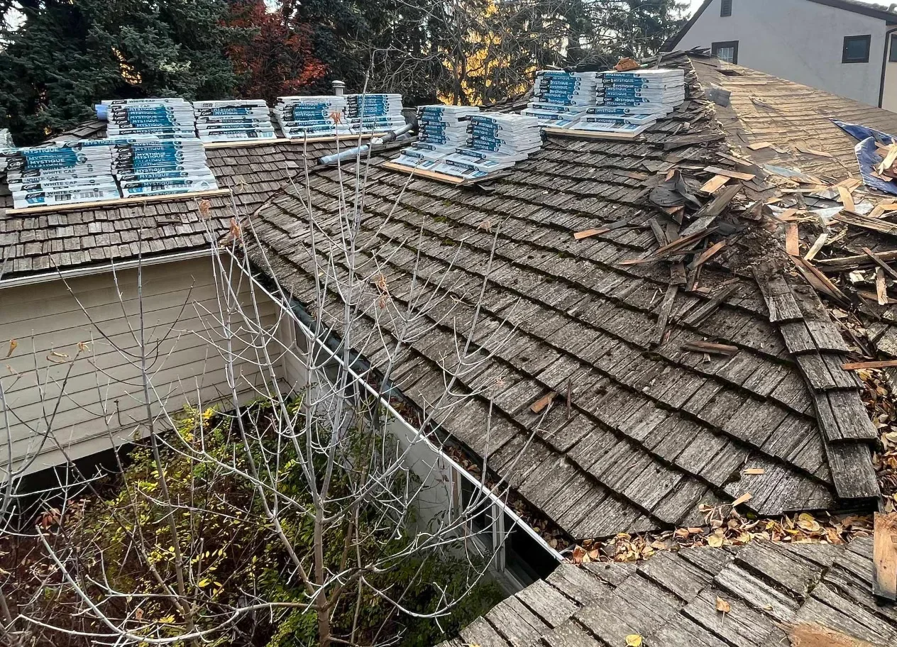 The old cedar shake roof with new materials loaded, before tear-off, Calgary, AB