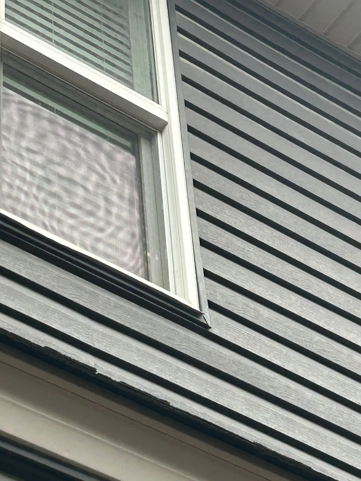 Siding beside a window checked for hail damage, Calgary