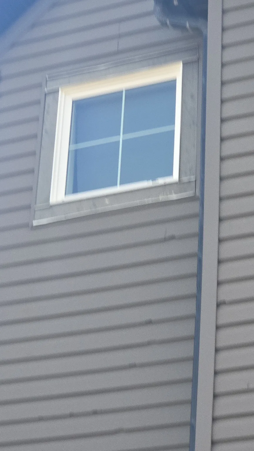 Hail damage on siding near a window, Calgary