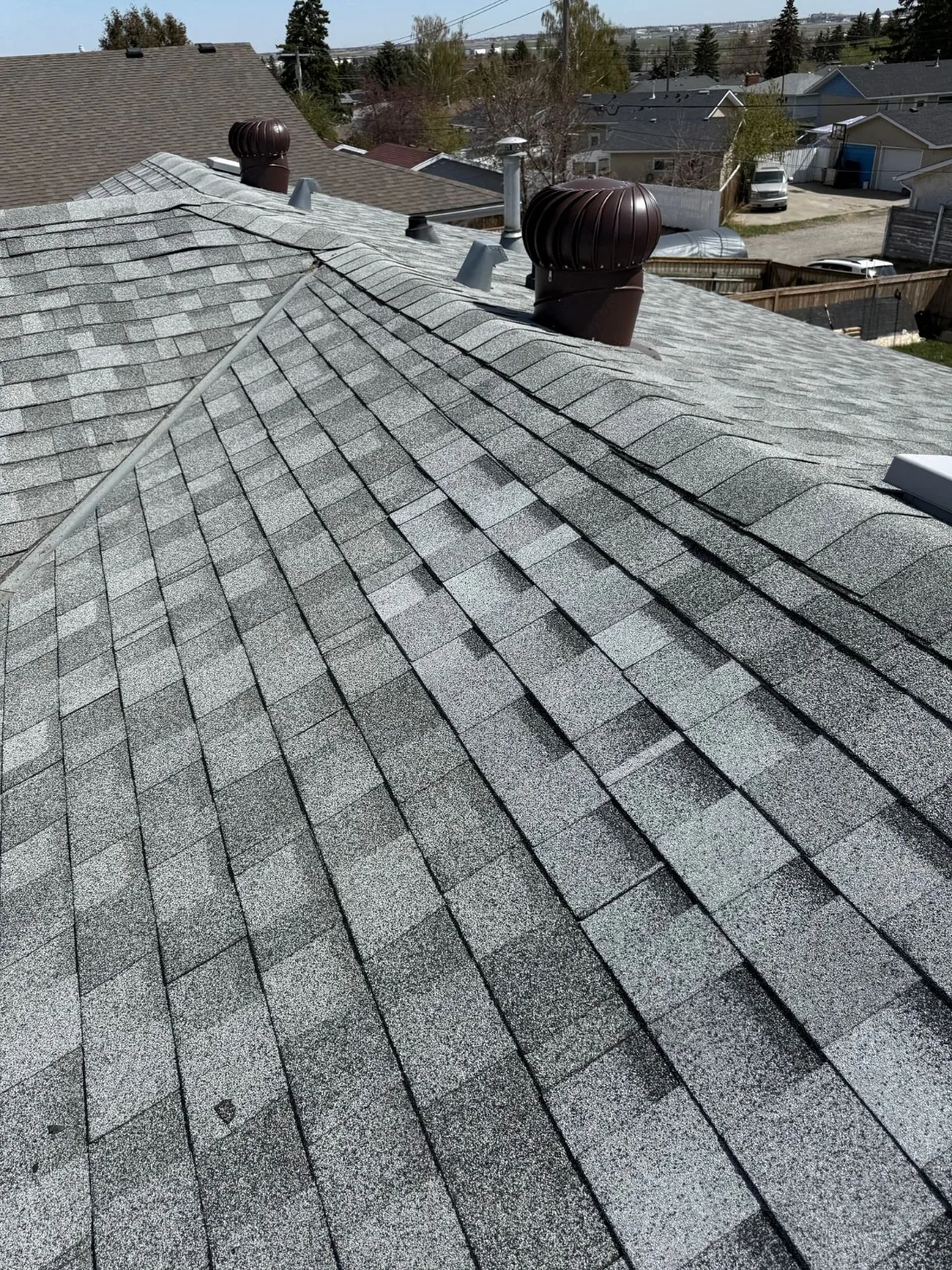 A roof hip and vents checked after wind, Calgary