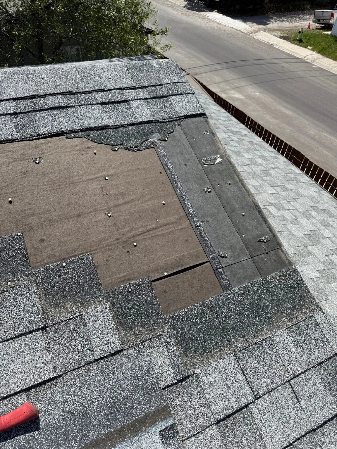 Shingles blown off down to the roof deck after a windstorm, Calgary