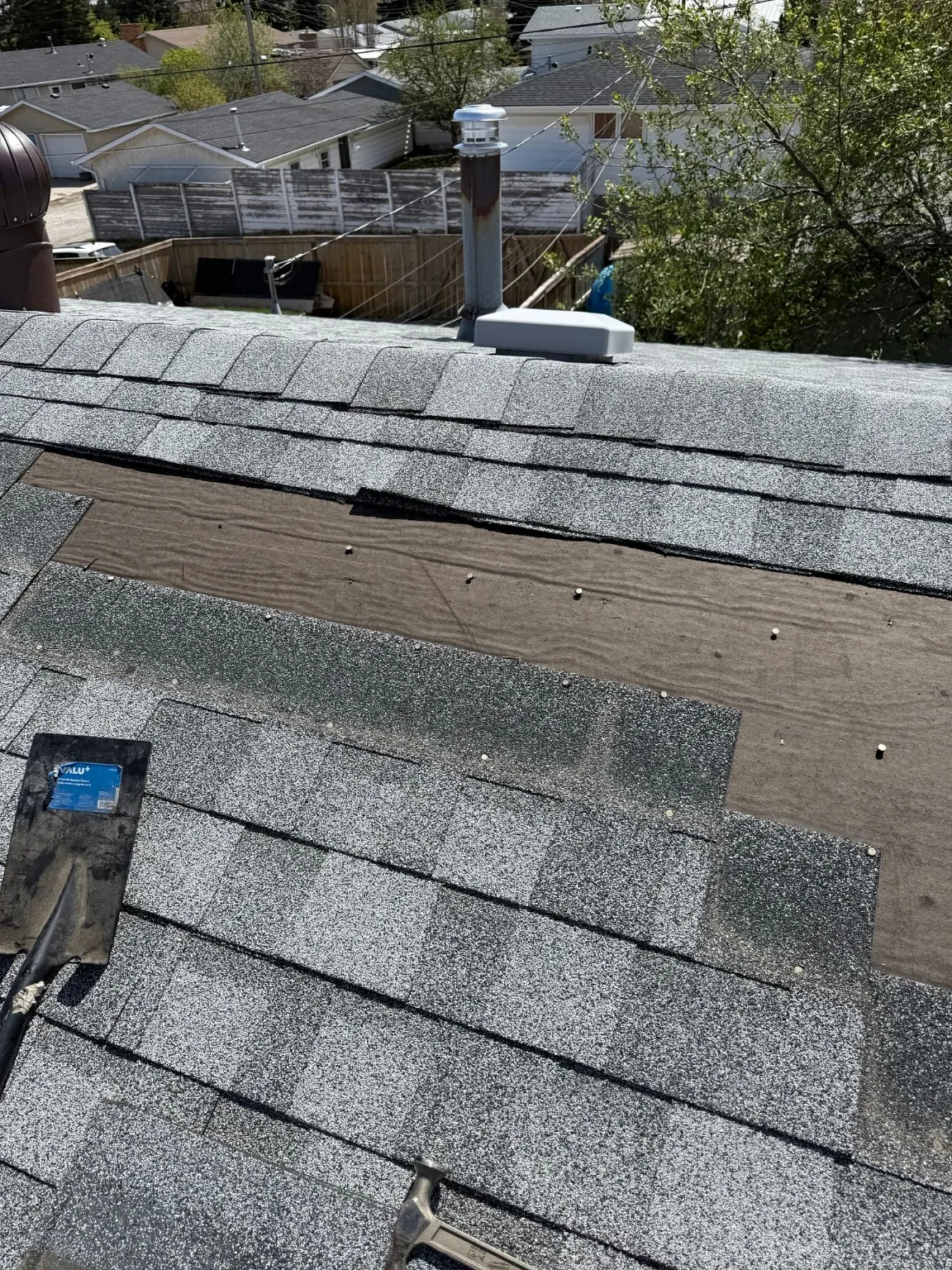 A blown-off shingle section next to roof vents, Calgary