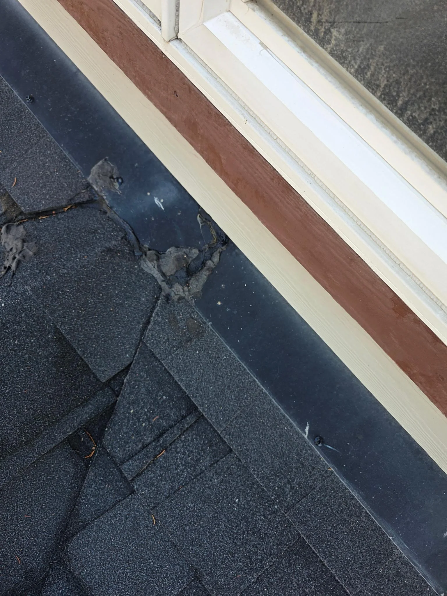 Worn shingles at a roof-to-wall flashing, Edgewater, BC
