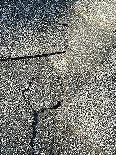 Close-up of a cracked asphalt shingle from age, Elbow Park, Calgary, AB