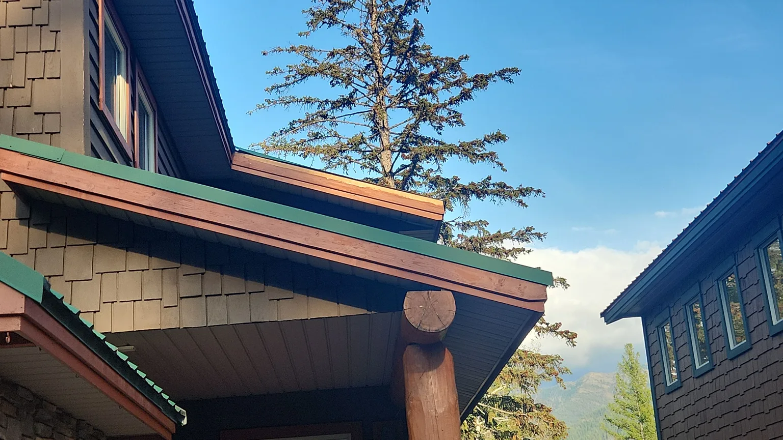 Mountain home gable with broken metal trim removed before repair, Fernie, BC