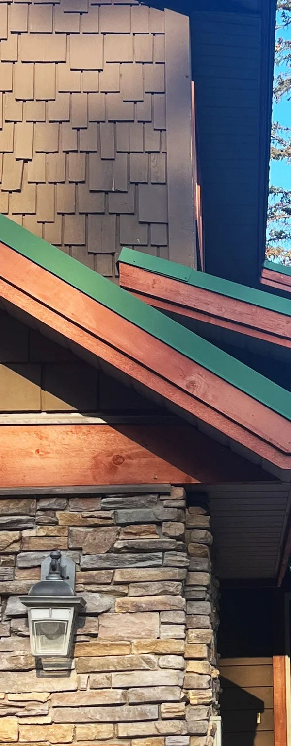 New custom green metal trim along the gables of a cedar shake home, Fernie, BC