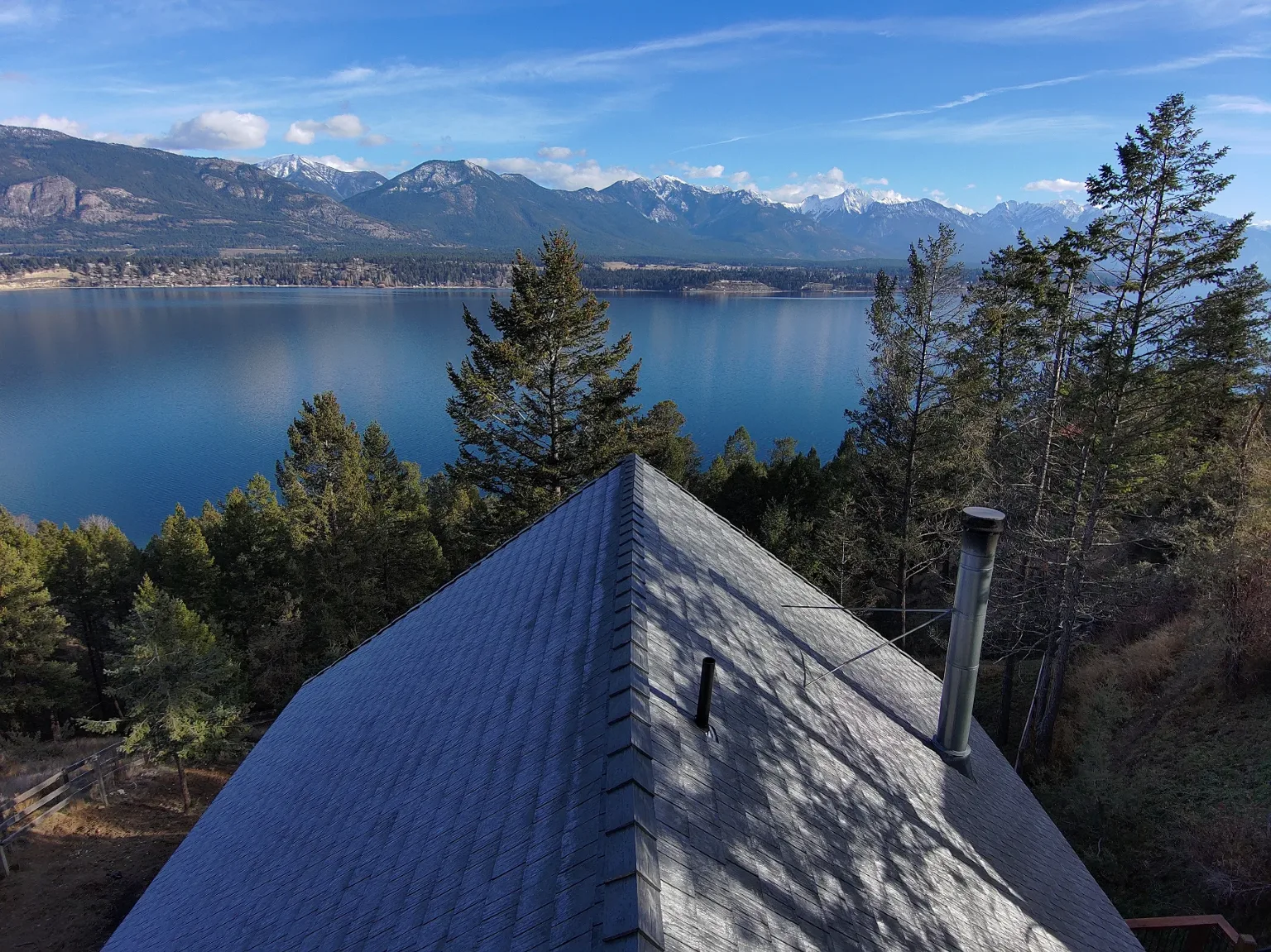 Euroshield rubber roof on a log A-frame cabin with Lake Windermere and mountains behind, Invermere, BC