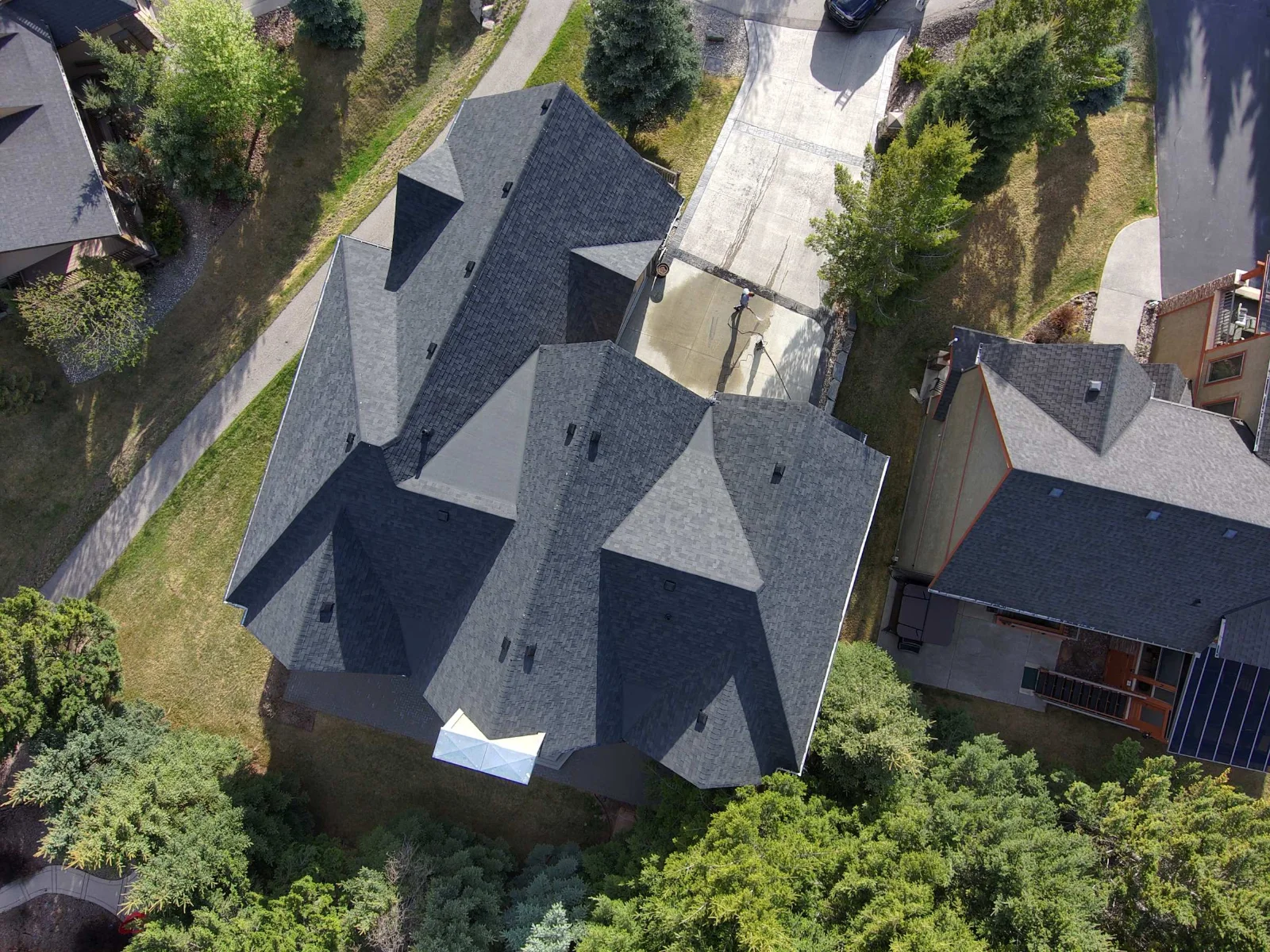 Aerial view of the finished Midnight Black roof among the trees, Invermere, BC