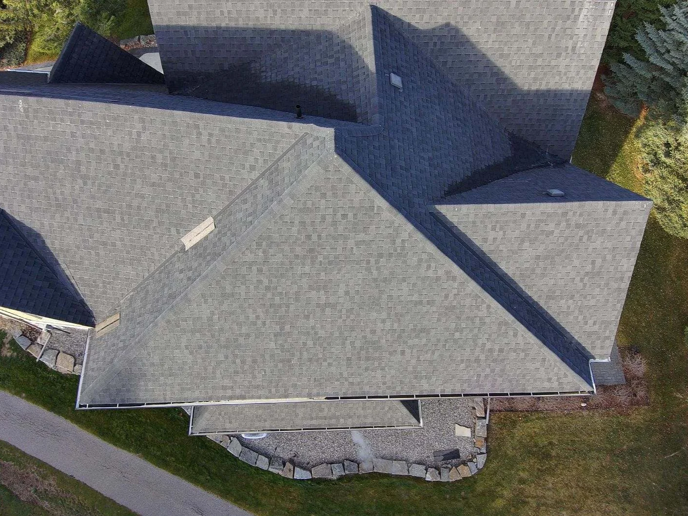 The original weathered asphalt shingle roof seen from above, before replacement, Invermere, BC