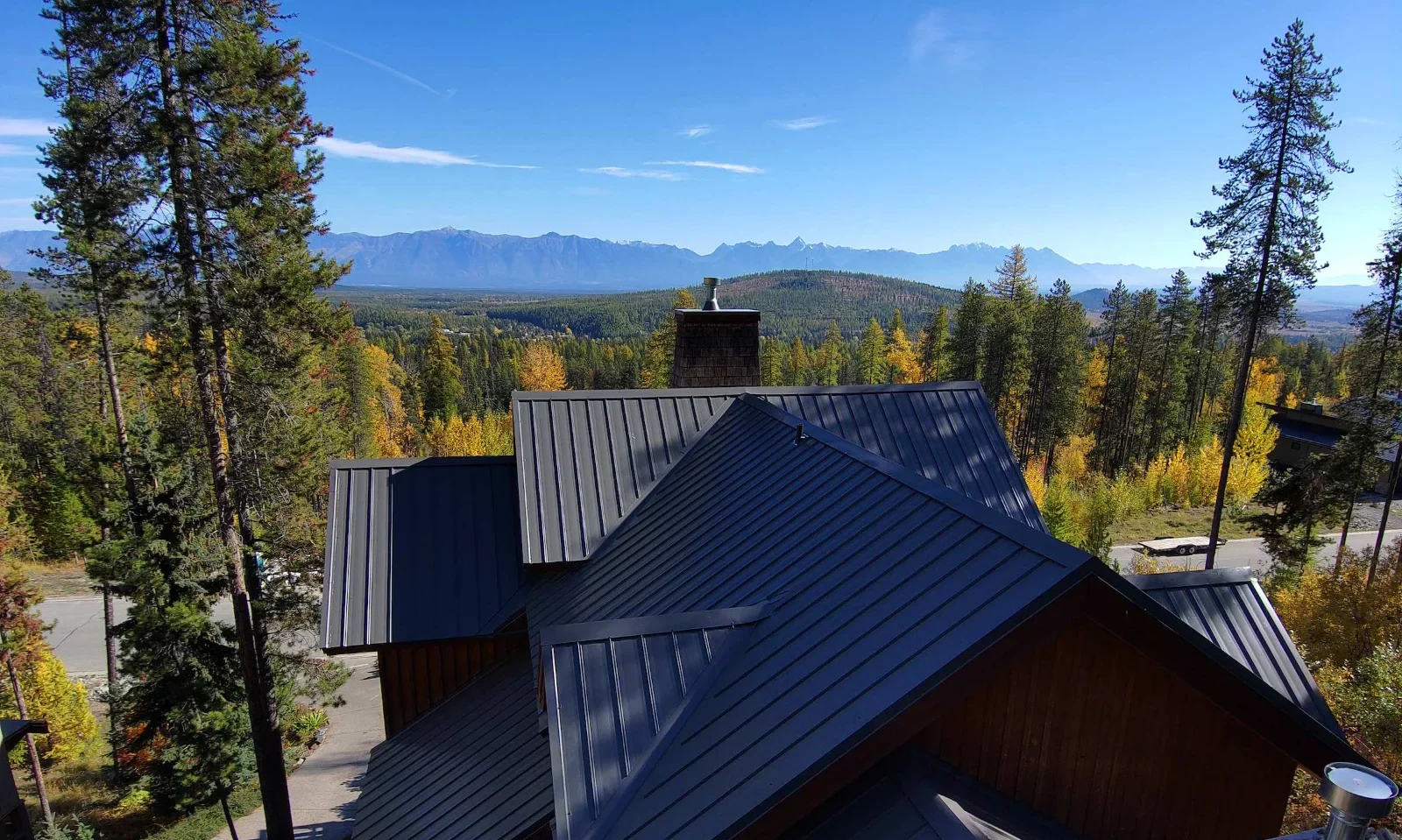 New charcoal standing seam metal roof with the Rocky Mountains on the horizon, Kimberley, BC