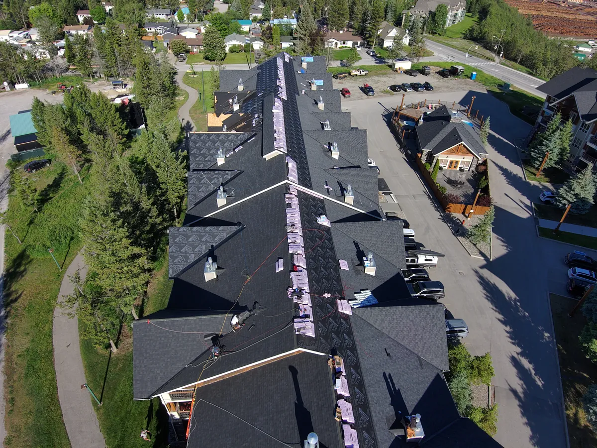 Drone view of a roof replacement in progress on a Radium Hot Springs condo building