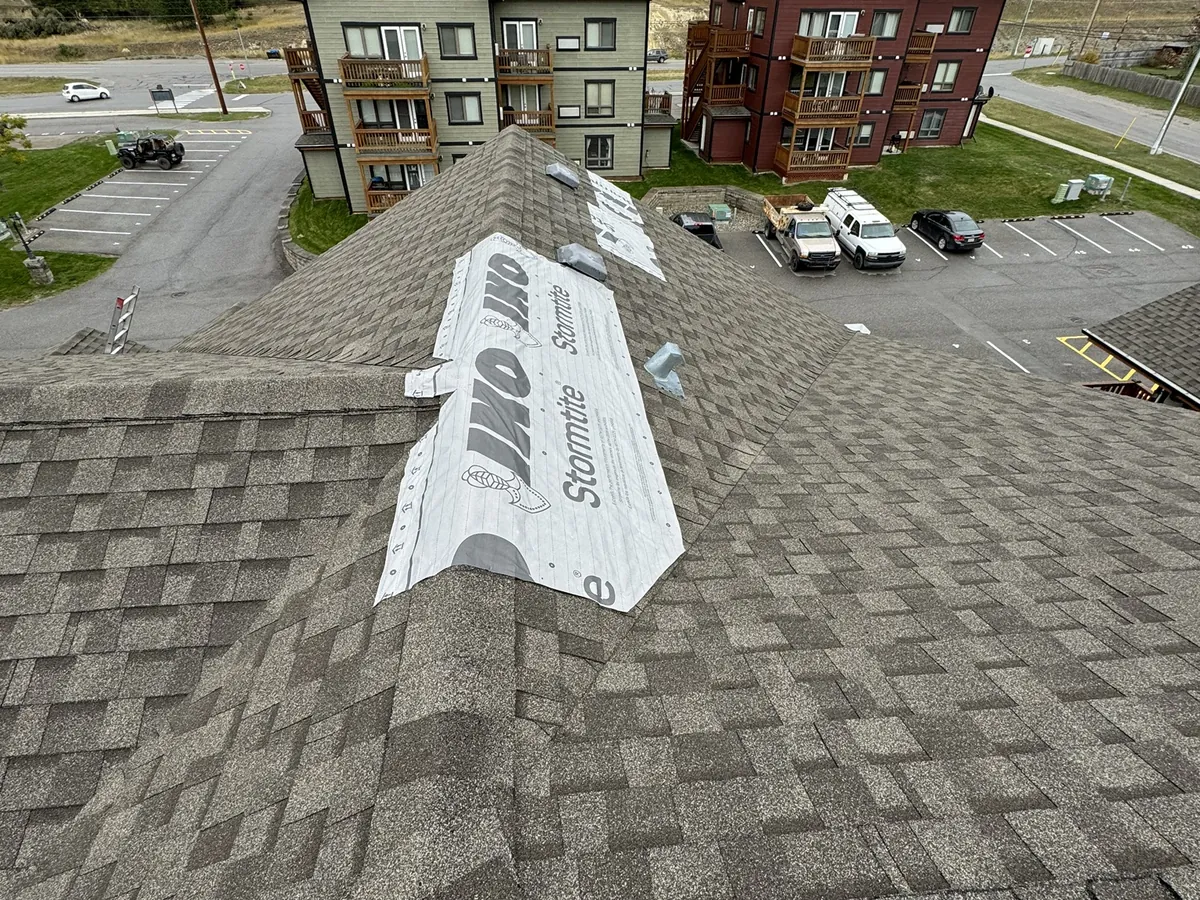 Wind-damaged shingles on a Radium Hot Springs roof before repair