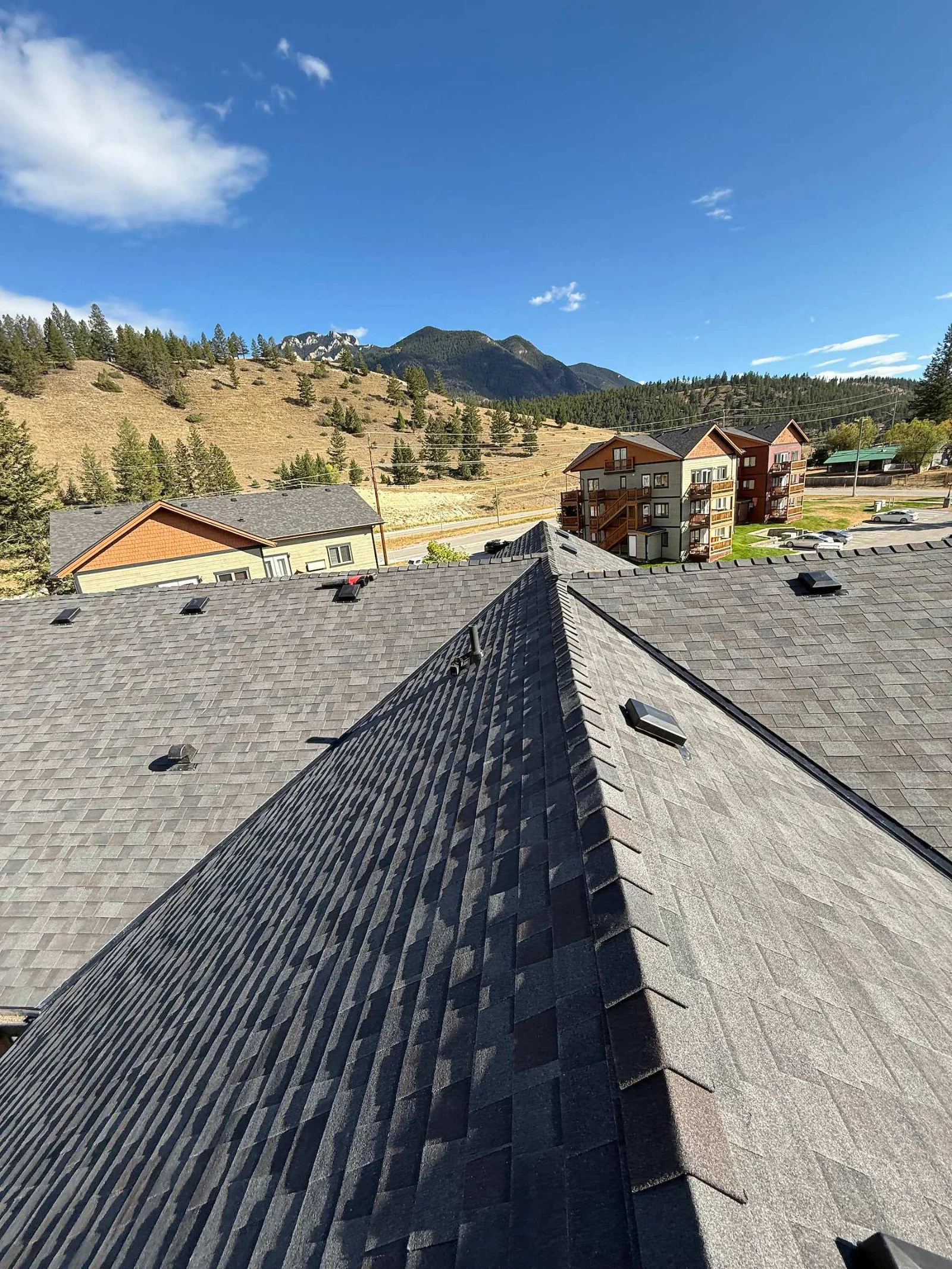 New shingles meeting the old along a ridge during the replacement, Radium Hot Springs, BC