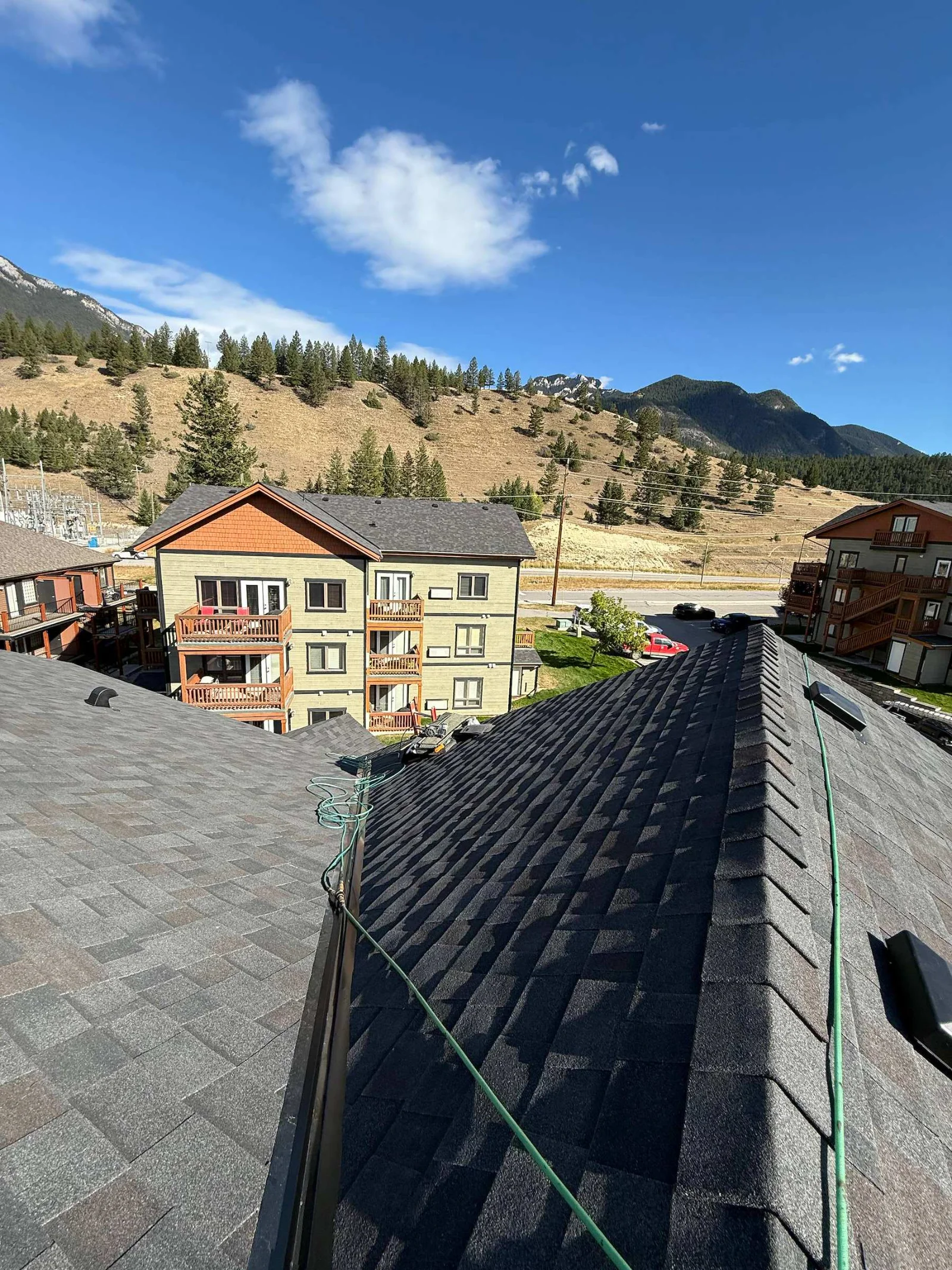 Old weathered shingles on one slope and new shingles on the other, mid-project, Radium Hot Springs, BC