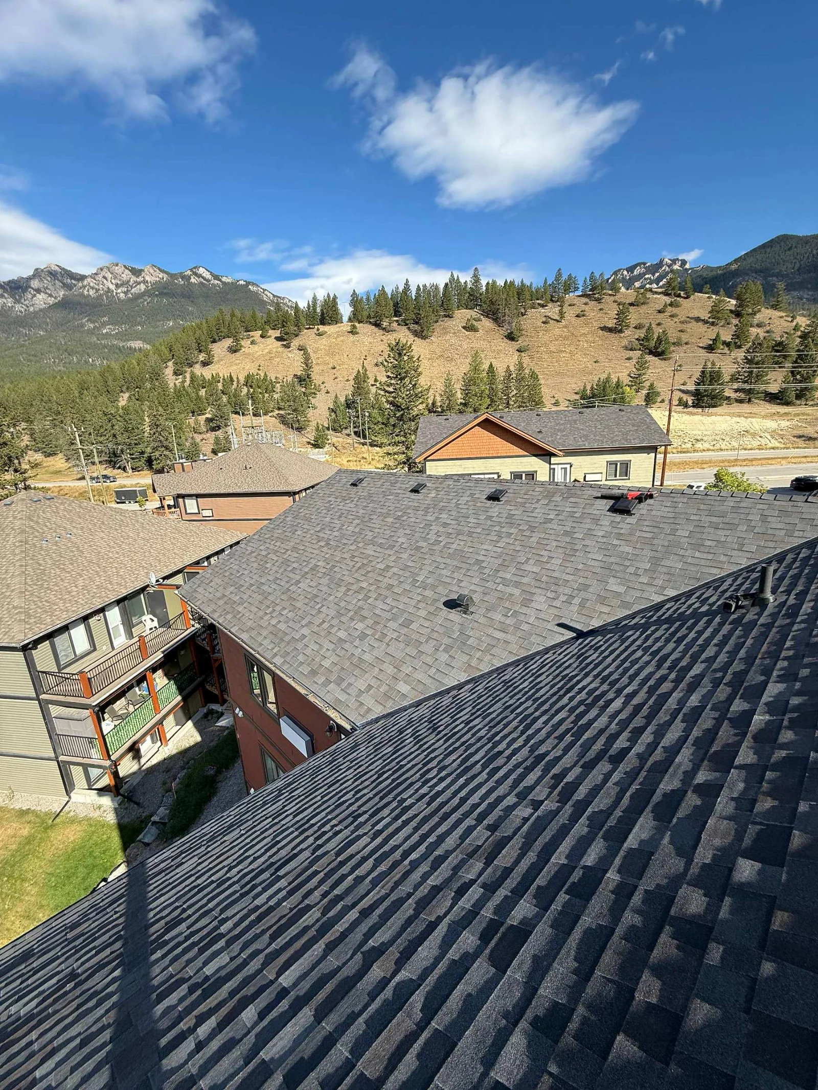 New shingles across the strata roofs with the mountains behind, Radium Hot Springs, BC