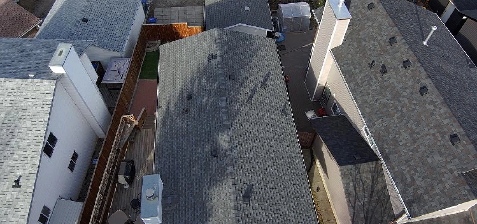 Overhead view of roof slopes and vents before replacement, Riverbend, Calgary, AB