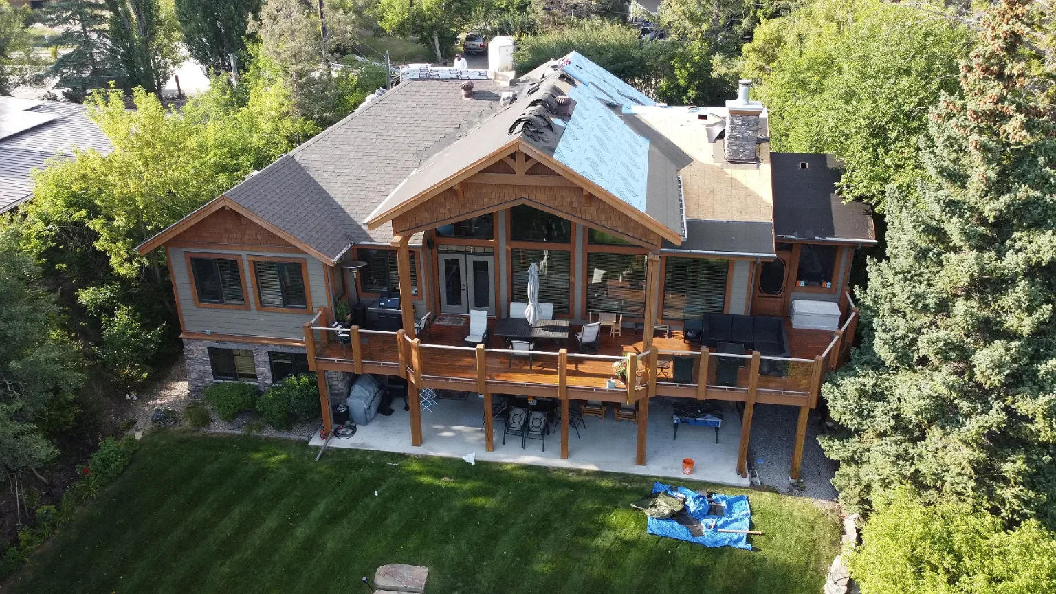 Overhead view of a large lakeside home during a roof replacement, Windermere, BC
